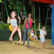 Los niños y niñas en el parque infantil acompañados de sus padres.