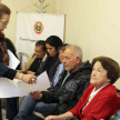 La abogada Alba Arriola, coordinadora del proyecto, entregando documentos a los presentes en la reunión.