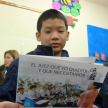 Un estudiante lee el contenido de la campaña educativa.