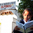 Una Alumna observando el material sobre los Derechos del niño y la niña, presente del ministro para la biblioteca de la escuela