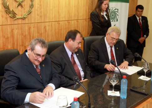 El presidente de la Corte Suprema, doctor Antonio Fretes, y el director de Yacyreta, Juan Schmalko firman el convenio, mientras observa el vicepresidente de la República Juan Afara.