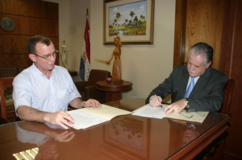 El ministro Victor Nuñez momento en que firma el convenio con el representante de la Editora Intercontinental