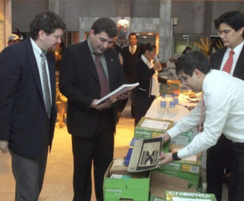 El magistrado Carlos Escobar observando los libros donados esta mañana por el Club Centenario