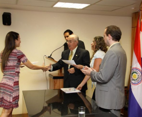 Instante en que el ministro Miguel Oscar Bajac entrega su certificado a una de las participantes del curso taller. 